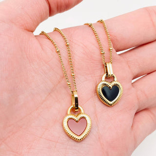 Gold plated stainless steel necklace with a two-sided enamel heart pendant, black on one side, pink on the other